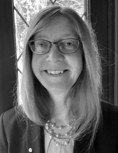 A black and white photo of Rachel Warren wearing glasses.