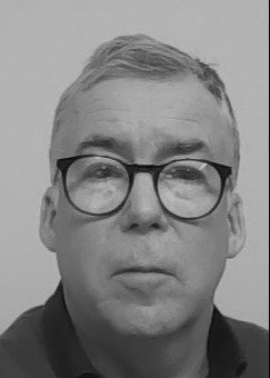 A black and white photo of Kevin Horsburgh wearing glasses.