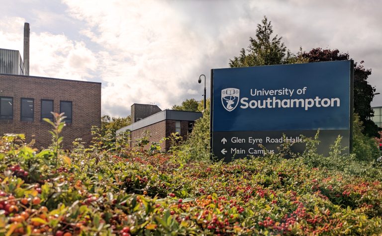The University of Southampton sign is surrounded by bushes.
