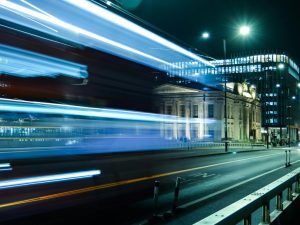 Dynamic nighttime shot of electric bus in motion across London Bridge in London, UK. Photo by Mert Çelik via Pexels.