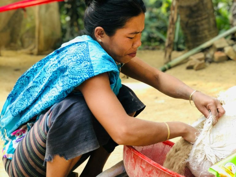 A woman in Rangamati, Bangladesh, handles soil and plants as she prepares to grow food. Photo by Rahabi Khan via Unsplash