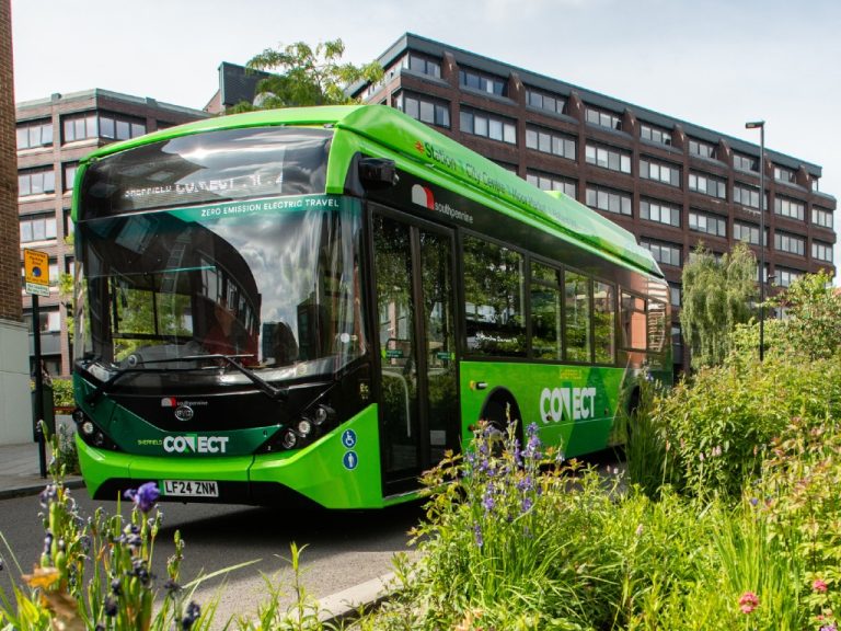 Electric bus near green planting in the city of Sheffield, UK.