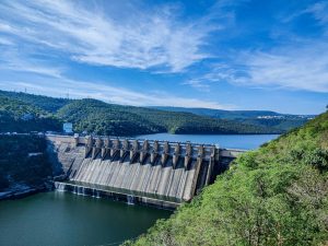 Srisailam Dam Reservoir on the Krishna River, one of India's largest dams, surrounding by fecund hills and a big blue sky with wispy clouds.