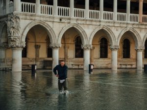 Man walking across a flooded Piazza San Marco in Venice, Italy