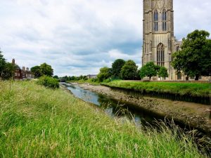 A scenic view of St Botolph's Church beside a river in Boston, England, United Kingdom
