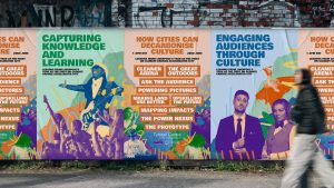 Graphic of a blurred-out personal walking past a series of wall posters, mocked up with pages from a report from the University of Manchester, "How Cities Can Decarbonise Culture: Lessons from Liverpool's year as the first UN Climate Accelerator City"
