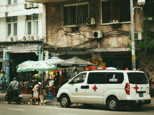 Busy street scene with an ambulance in front of apartment buildings in Ho Chi Minh City, Vietnam.
