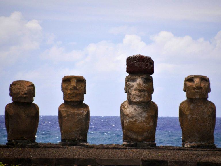 The Moai statues of Rapa Nui on Easter Island in Chile, stood in front of still sea behind them: one of many coastal world heritage sites which may be vulnerable to climate threats.