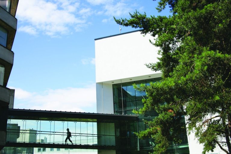 Silhouetted figure walking the Zuckerman Institute for Connective Environmental Research (ZICER) walkway that leads to the School of Environmental Sciences at the University of East Anglia (UEA) campus in Norwich, UK